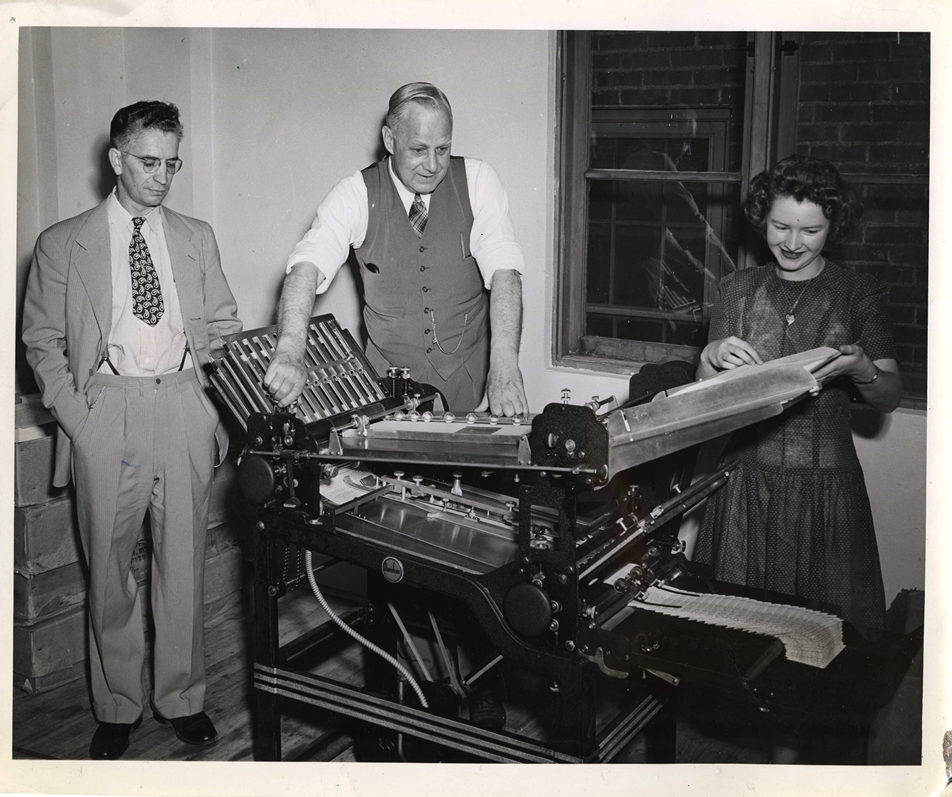 Photograph of William Walter DeBolt, Frank B. Robinson, and unidentified female staff member working at a sorter